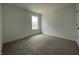 Minimalist bedroom featuring beige carpet, a window, and white walls at 1319 Fleming Dr, Greenfield, IN 46140