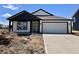 New construction home with white siding, black trim, and a two-car garage, set against a blue sky at 1319 Fleming Dr, Greenfield, IN 46140