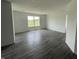 Bright living room featuring gray wood floors, a window, and white walls at 1319 Fleming Dr, Greenfield, IN 46140