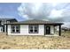 Rear exterior of a modern home featuring a covered porch, white siding and black trim at 1319 Fleming Dr, Greenfield, IN 46140