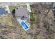 Aerial shot revealing a backyard oasis with a sparkling pool, outdoor seating, and surrounding trees at 13705 Beam Ridge Dr, McCordsville, IN 46055