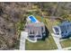 Aerial view of a home with in-ground pool, lush lawn, mature trees, and a circular driveway at 13705 Beam Ridge Dr, McCordsville, IN 46055