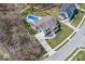 A luxurious home from an aerial perspective, showcasing a pool, landscaping, and surrounding trees at 13705 Beam Ridge Dr, McCordsville, IN 46055