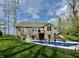 An expansive backyard features a pristine pool, lush landscaping, and a well-maintained lawn under a partly cloudy sky at 13705 Beam Ridge Dr, McCordsville, IN 46055