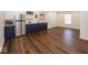 Finished basement with modern bar featuring navy blue cabinets, stainless fridge and hard wood flooring at 13705 Beam Ridge Dr, McCordsville, IN 46055