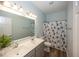 Bright bathroom with double sink vanity, wood-look flooring, and a hockey themed shower curtain at 13705 Beam Ridge Dr, McCordsville, IN 46055