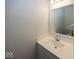 Neutral-toned bathroom with a white single sink vanity, a large mirror, and ample lighting above at 13705 Beam Ridge Dr, McCordsville, IN 46055