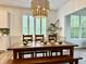 The dining room features a stylish light fixture, a wooden table with bench seating, and views of the outdoor scenery at 13705 Beam Ridge Dr, McCordsville, IN 46055