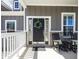 Close-up of the front door with a wreath, flanked by rocking chairs, and surrounded by stylish architectural details at 13705 Beam Ridge Dr, McCordsville, IN 46055