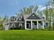 Charming home featuring a covered front porch with white columns, dormer windows and manicured lawn at 13705 Beam Ridge Dr, McCordsville, IN 46055