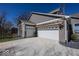 Attached two-car garage featuring brick siding, white doors, and a charming pergola with stone landscaping at 13705 Beam Ridge Dr, McCordsville, IN 46055