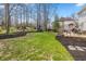 Backyard features include lush lawn, mature trees, a playhouse, and inviting deck with seating at 14491 Jeremy Dr, Carmel, IN 46033