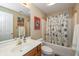Well-lit bathroom featuring a shower-tub combo, vanity with sink, and decorative floral shower curtain at 14491 Jeremy Dr, Carmel, IN 46033