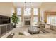 Spacious living room with a cozy fireplace, tall windows, and comfortable seating for relaxation and entertaining guests at 14491 Jeremy Dr, Carmel, IN 46033