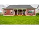 A backyard of a house with a lawn and covered porch that features white columns and a ceiling fan with double doors at 15144 Bentfield Ct, Fishers, IN 46037