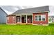 A backyard of a home with a lawn and a covered porch featuring white columns, a ceiling fan, and double doors at 15144 Bentfield Ct, Fishers, IN 46037