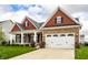 Lovely home showcasing a spacious two-car garage, stone accents, and a neatly kept lawn with lush green grass at 15144 Bentfield Ct, Fishers, IN 46037