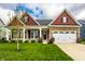 Charming single-Gathering home featuring a stone facade, two-car garage, and a well-manicured front lawn at 15144 Bentfield Ct, Fishers, IN 46037