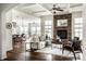 Open-concept living room boasts a stone fireplace, ceiling fan, and seamless flow to kitchen and dining areas at 15144 Bentfield Ct, Fishers, IN 46037