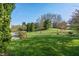Expansive backyard features lush lawn, mature trees, and serene sitting areas at 158 Bloomfield Ln, Westfield, IN 46074