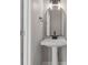 Stylish powder room with a modern pedestal sink, elegant mirror and neutral tones at 158 Bloomfield Ln, Westfield, IN 46074