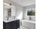 Modern bathroom boasts dual sinks, sleek fixtures, a standalone tub, and a large window with outdoor views at 158 Bloomfield Ln, Westfield, IN 46074