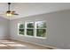 Bright living room featuring hardwood floors, a ceiling fan, and three large windows with green views at 158 Bloomfield Ln, Westfield, IN 46074