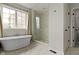 This bright bathroom features a soaking tub, frameless glass shower, and white marble tile at 1747 Wellpark Dr, Westfield, IN 46074