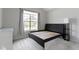 Minimalist bedroom with a platform bed frame and large windows offering natural light, complemented by soft grey walls at 1747 Wellpark Dr, Westfield, IN 46074