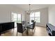 Modern dining room with glass table, gray chairs, chandelier, and sliding glass doors to the outside at 1747 Wellpark Dr, Westfield, IN 46074