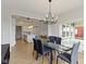 Modern dining room with glass table and gray chairs is adjacent to the kitchen and living room at 1747 Wellpark Dr, Westfield, IN 46074