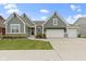 Charming two-story home featuring a three-car garage, craftsman style architecture, and a beautifully landscaped front yard at 1747 Wellpark Dr, Westfield, IN 46074