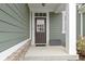 Elegant front door with glass paneling and a modern door lock, surrounded by neutral siding and manicured landscaping at 1747 Wellpark Dr, Westfield, IN 46074