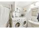 Small bathroom featuring washing machine, dryer, sink and bathtub with a shower curtain at 1850 Cruft St, Indianapolis, IN 46203
