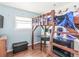 A bedroom with hardwood floors features a bunk bed, desk, and fun space-themed decor at 1850 Cruft St, Indianapolis, IN 46203