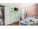A bedroom features mint green and pink walls, hardwood floors, a dresser, and a closet at 1850 Cruft St, Indianapolis, IN 46203