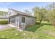 Side view of a detached gray garage with a black garage door and a gray entry door to the backyard at 1850 Cruft St, Indianapolis, IN 46203