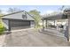 View of detached gray garage with a black garage door, basketball hoop, deck, and covered seating area at 1850 Cruft St, Indianapolis, IN 46203