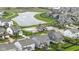 Aerial view of a residential neighborhood featuring lush lawns, community pool, playground, and a picturesque pond at 1979 Lunenburg Dr, Westfield, IN 46074