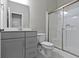 Bathroom with gray cabinets, white shower with glass door and fixtures at 1979 Lunenburg Dr, Westfield, IN 46074