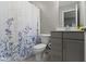 Full bathroom featuring a toilet, gray cabinets, sink, faucet and a shower curtain at 1979 Lunenburg Dr, Westfield, IN 46074