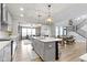 Open-concept kitchen featuring a gray island, modern lighting, and stainless steel appliances at 1979 Lunenburg Dr, Westfield, IN 46074