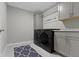 A modern laundry room with gray cabinets, countertop, and a black washer and dryer at 1979 Lunenburg Dr, Westfield, IN 46074