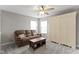 Comfortable living room with a brown sofa, ceiling fan, two windows, and a cabinet at 1979 Lunenburg Dr, Westfield, IN 46074