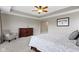 Comfortable main bedroom with tray ceiling, fan, dresser, and sitting chair at 1979 Lunenburg Dr, Westfield, IN 46074