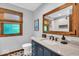 Updated bathroom features a sink vanity, marble countertop, framed mirror, and tile flooring at 2011 Pin Oak Ct, Indianapolis, IN 46260