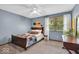 This bedroom features a ceiling fan, wood headboard, large window, and a dresser with a mirror at 2011 Pin Oak Ct, Indianapolis, IN 46260