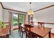 Bright dining room with wood table, accent lighting, and large windows overlooking the landscaped outdoors at 2011 Pin Oak Ct, Indianapolis, IN 46260