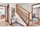 Inviting entryway with a wooden staircase, decorative mirror, tile flooring, and warm lighting fixtures at 2011 Pin Oak Ct, Indianapolis, IN 46260