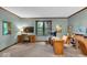 Well-lit office space with a large window, built-in storage, and neutral carpet at 2011 Pin Oak Ct, Indianapolis, IN 46260